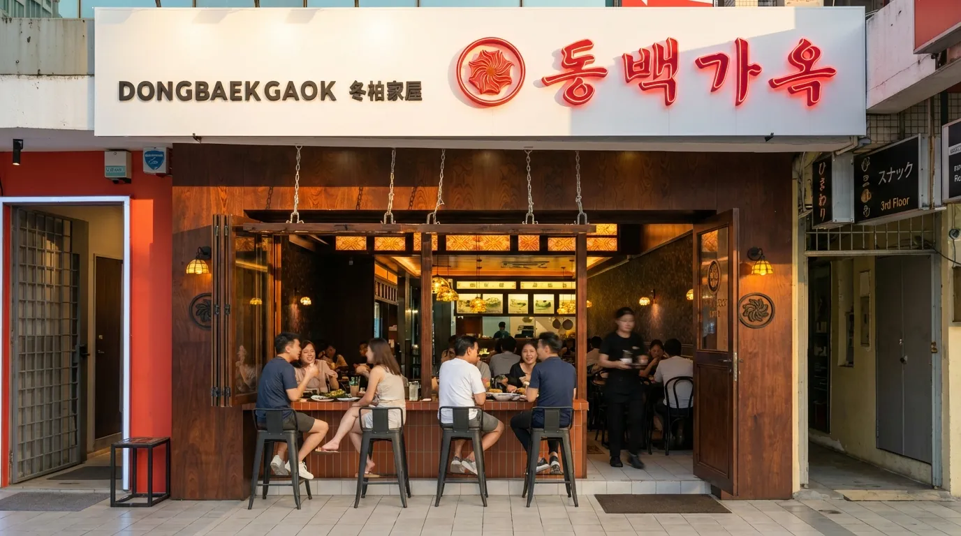 Dong Baek storefront with its red camellia sign and outdoor seating